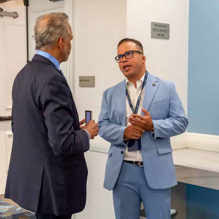 Two agents having a candid discussion in a hallway at a conference